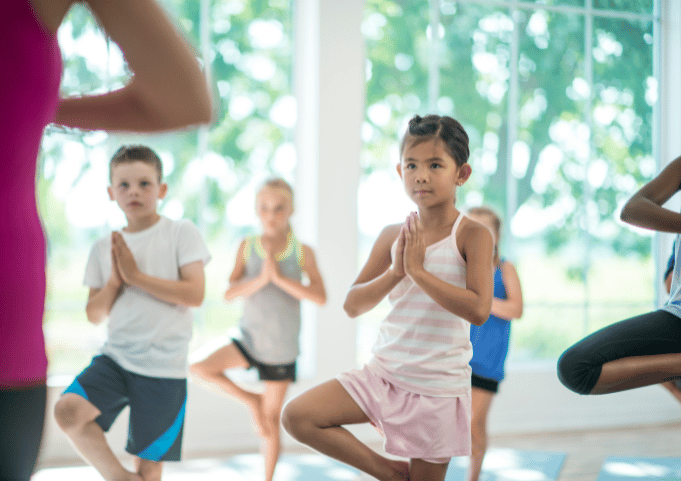 Kids Yoga class. Kids doing Tree Pose.