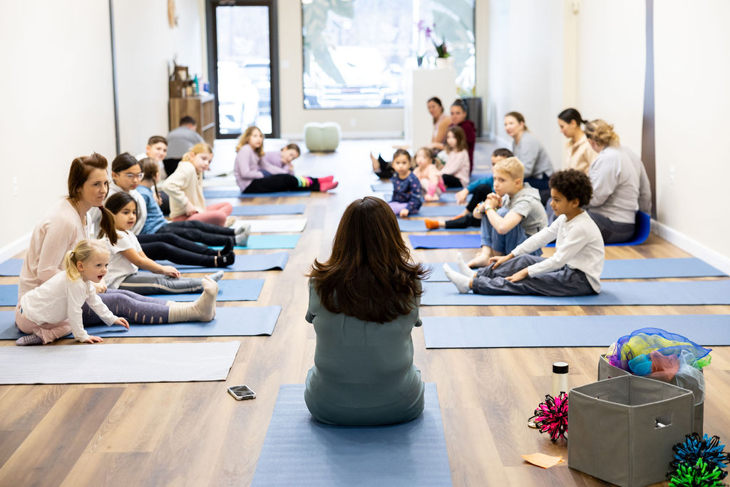 Adults and kids having fun at yoga & mindfulness class